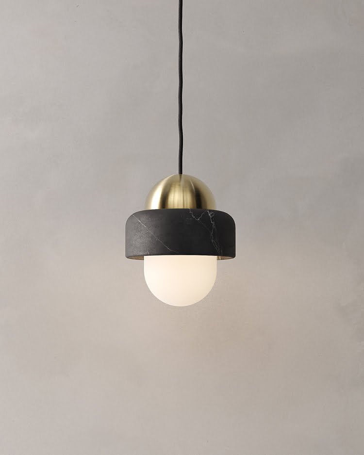 Lámpara colgante NAGA hecha de mármol negro y latón con difusor esférico de vidrio opalino diseñada por Bandido Studio.