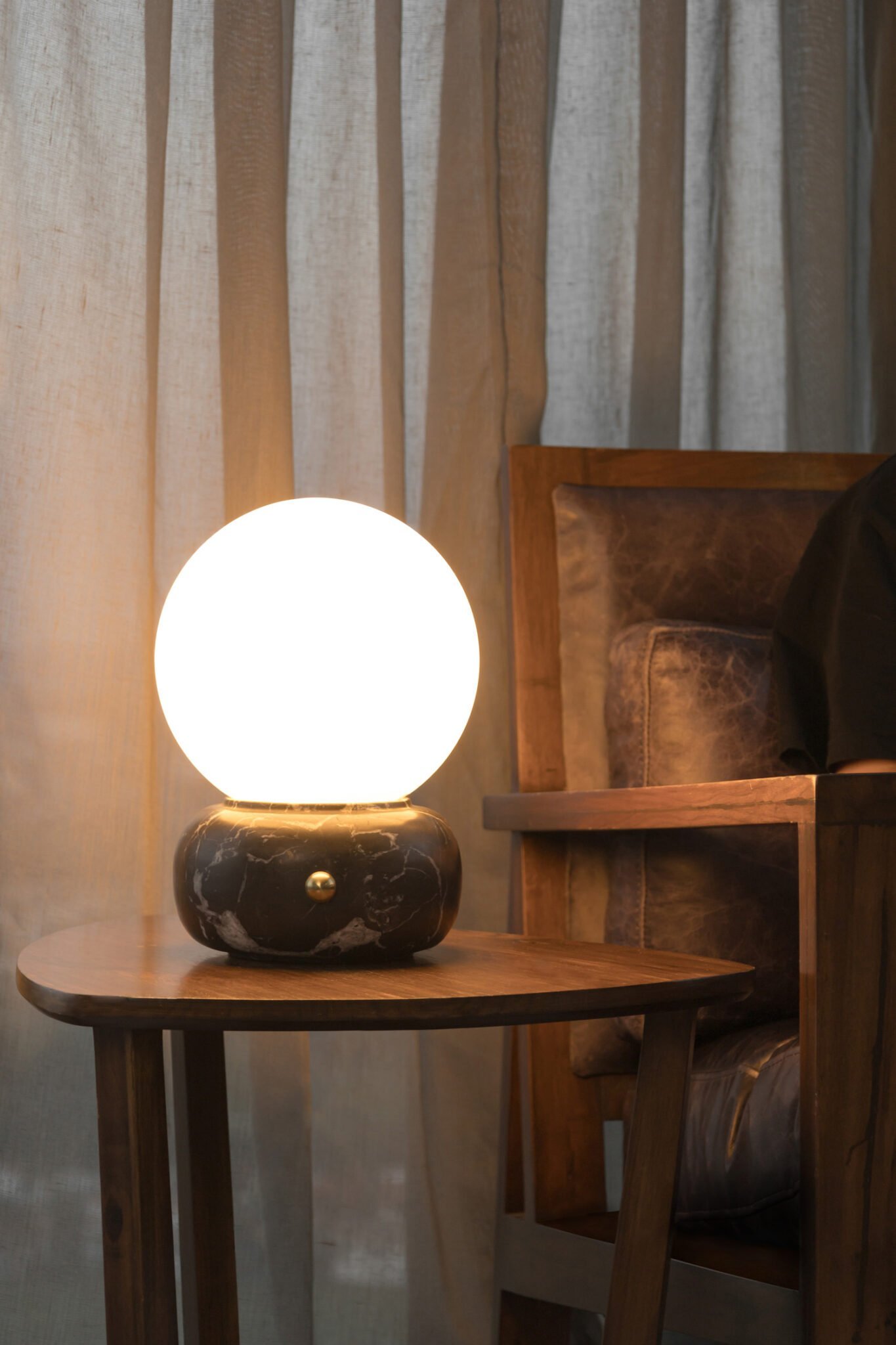 small table lamp made of black marble and warm light in living room.