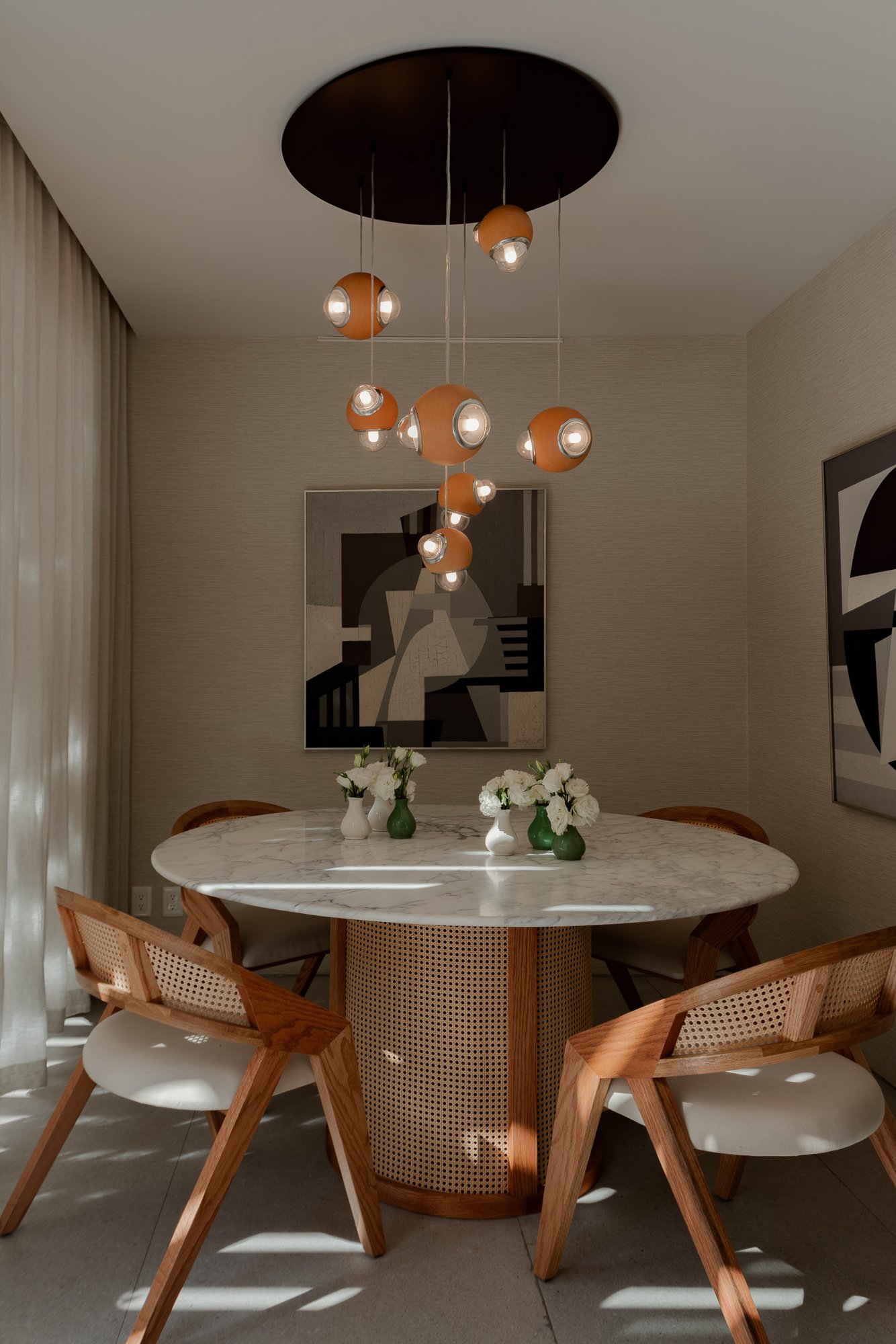 Set de lámparas colgantes HUMO color barro natural diseñadas por Bandido studio en comedor redondo en Casa Hotbook 2024