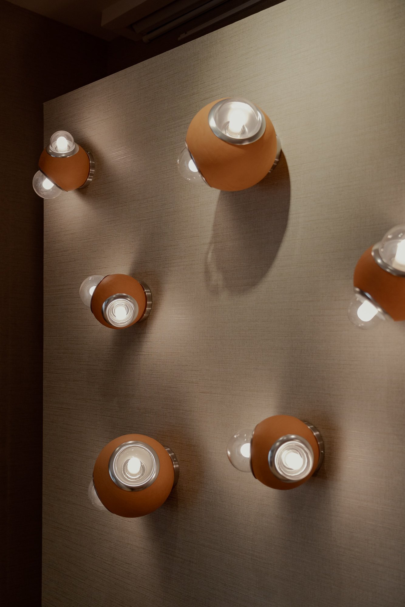 Acomodo de lámparas HUMO arbotantes color barro natural diseñadas por Bandido Lighting expuestas en Casa Hotbook 2024