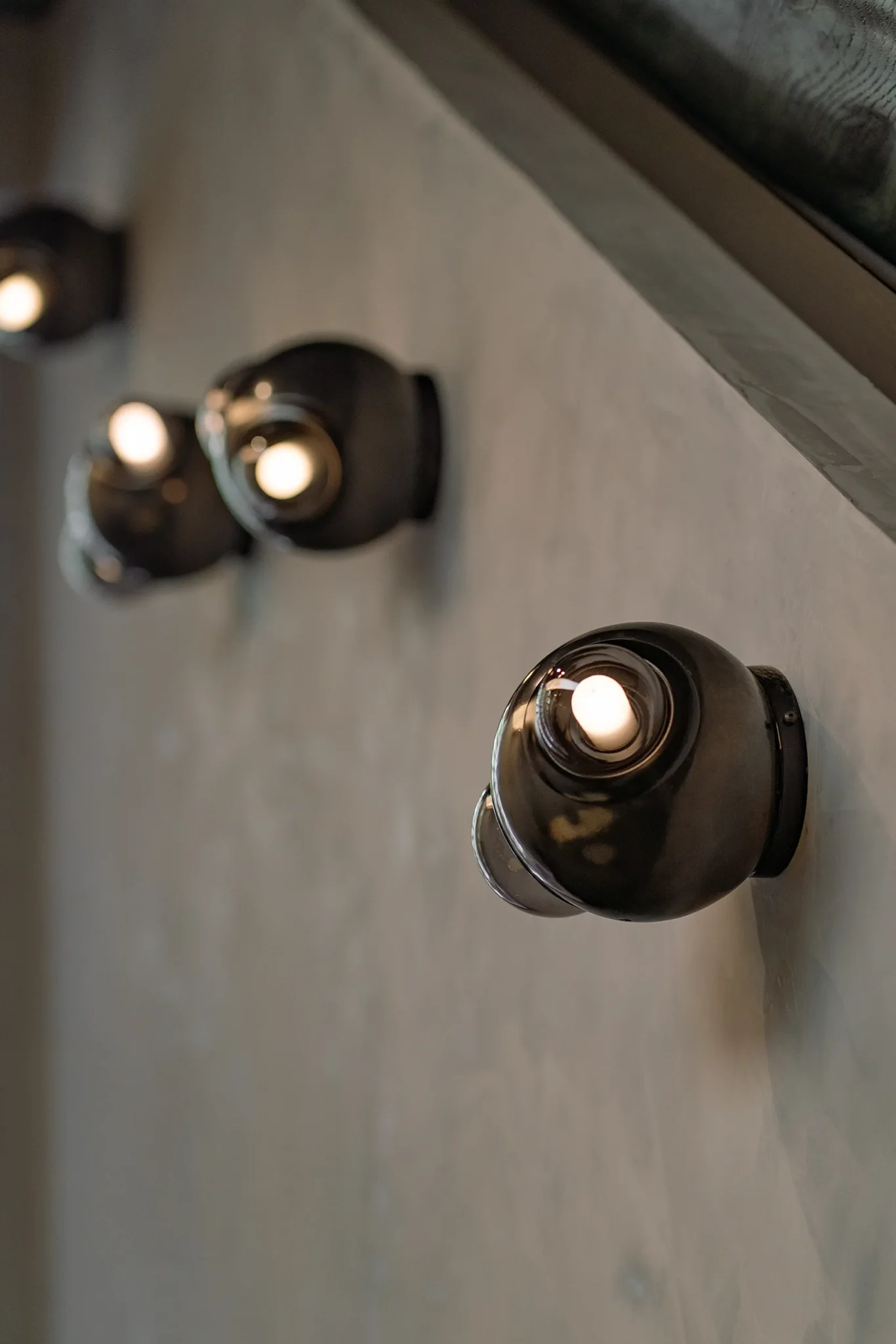 Set of HUMO wall lights in black clay and smoked diffusers designed by Bandido Studio in Santuario Espejo, a space designed by Grande Studio & Primitivo Taller at Design House 2025